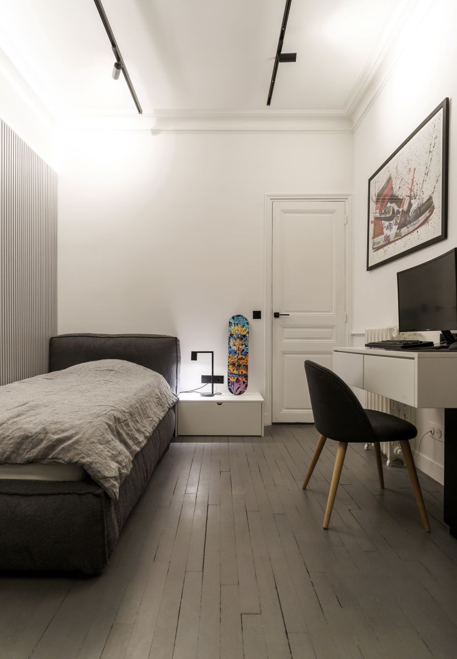 Minimalistická spálňa pre tínedžera s moderným nábytkom a dekoráciami.