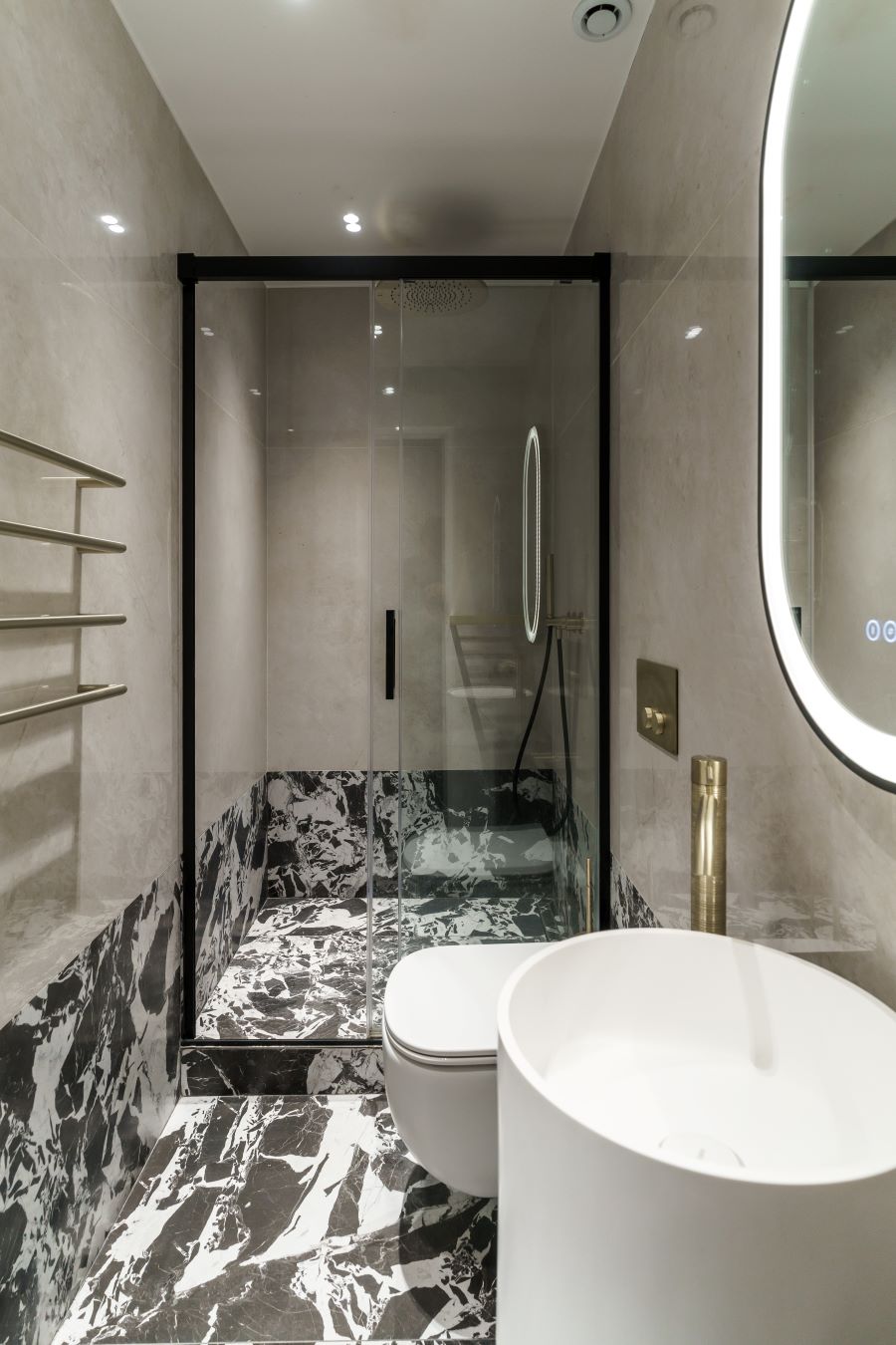 Luxusná kúpeľňa s moderným dizajnom, sprchovacím kútom a mramorovými detailmi.