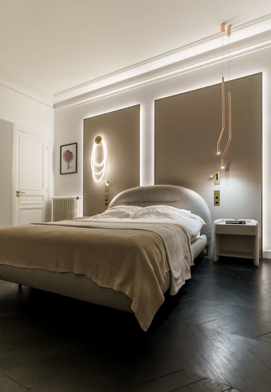 Štýlová spálňa s moderným osvetlením a pohodlnou posteľou.