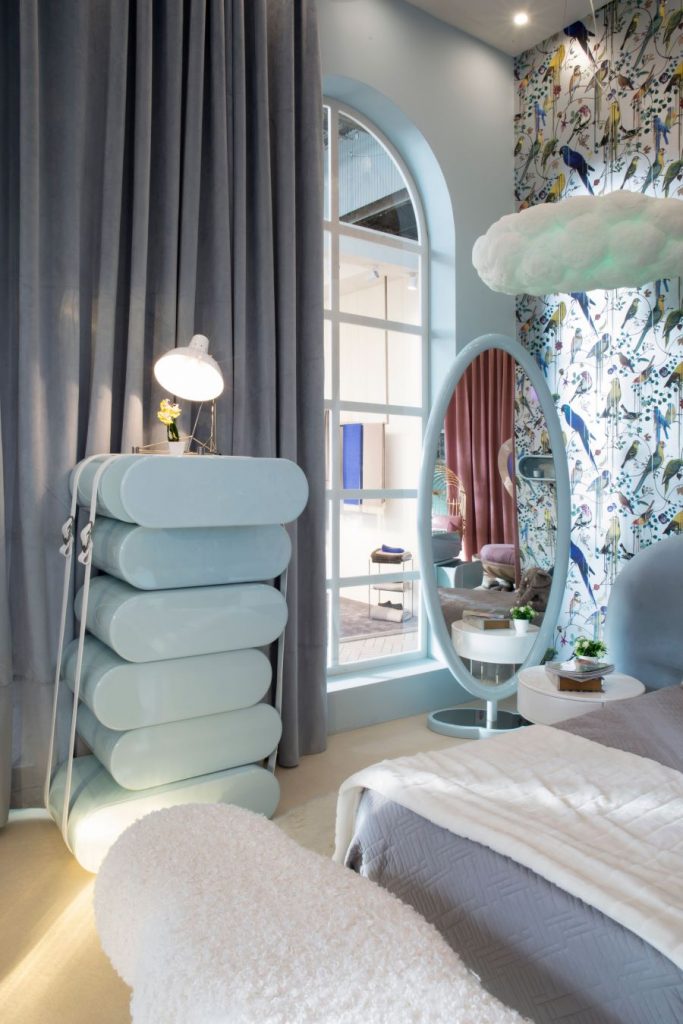 Moderná spálňa v pastelových farbách s kreatívnym nábytkom a zrkadlom.