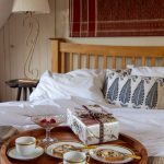 Romantická spálňa s raňajkami v posteli a dreveným nábytkom.