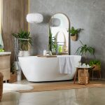 Štýlová kúpeľňa s voľne stojacou vaňou, zrkadlom a izbovými rastlinami.