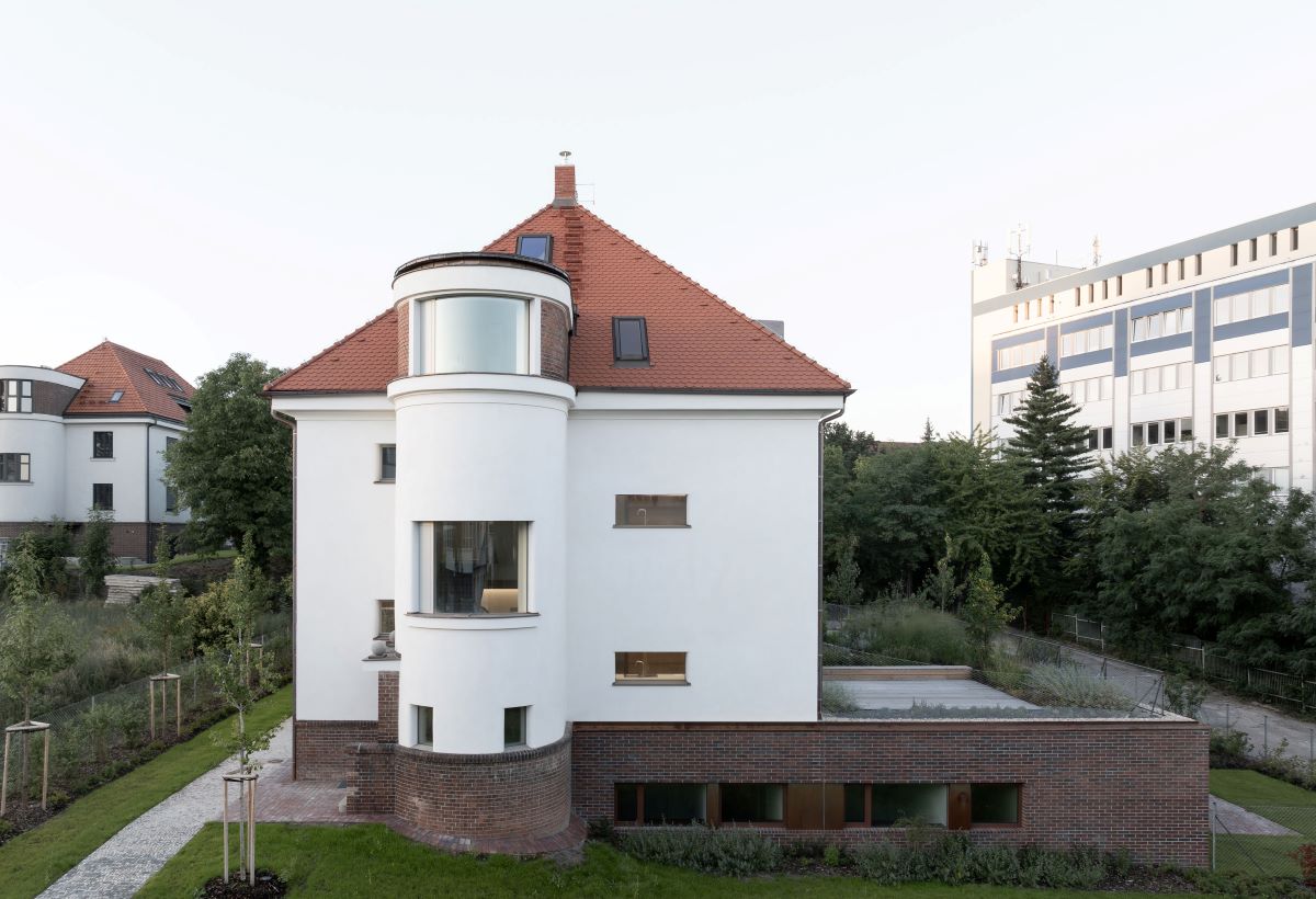 Rekonštruovaná historická vila na pražských Vinohradoch s modernou prístavbou a záhradou.