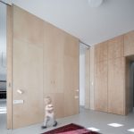 Moderný dizajn obývacieho priestoru v historickej vile na pražských Vinohradoch s drevenými obkladmi a minimalistickým nábytkom.