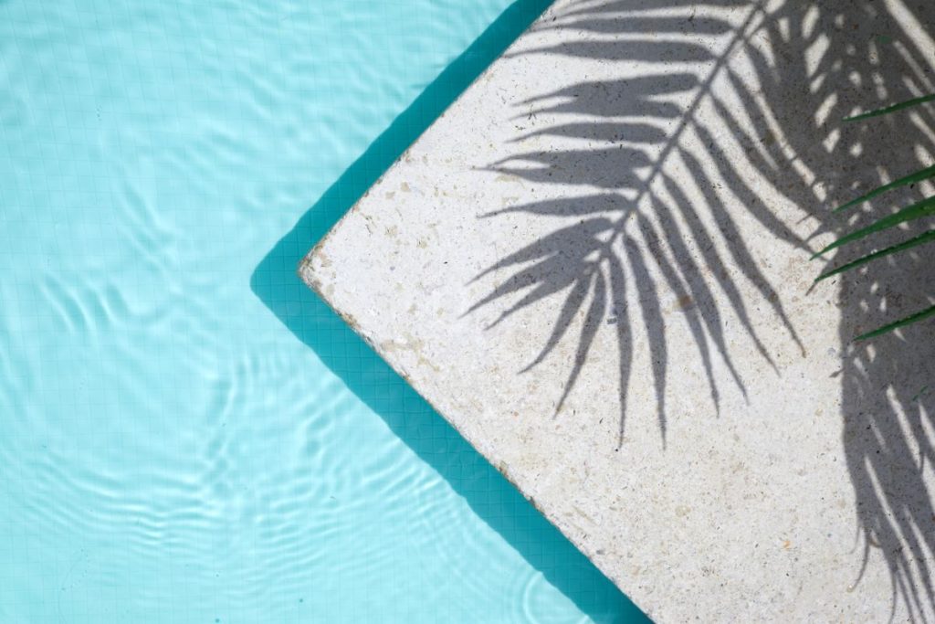 Detail na svetlú dlažbu pri bazéne.
