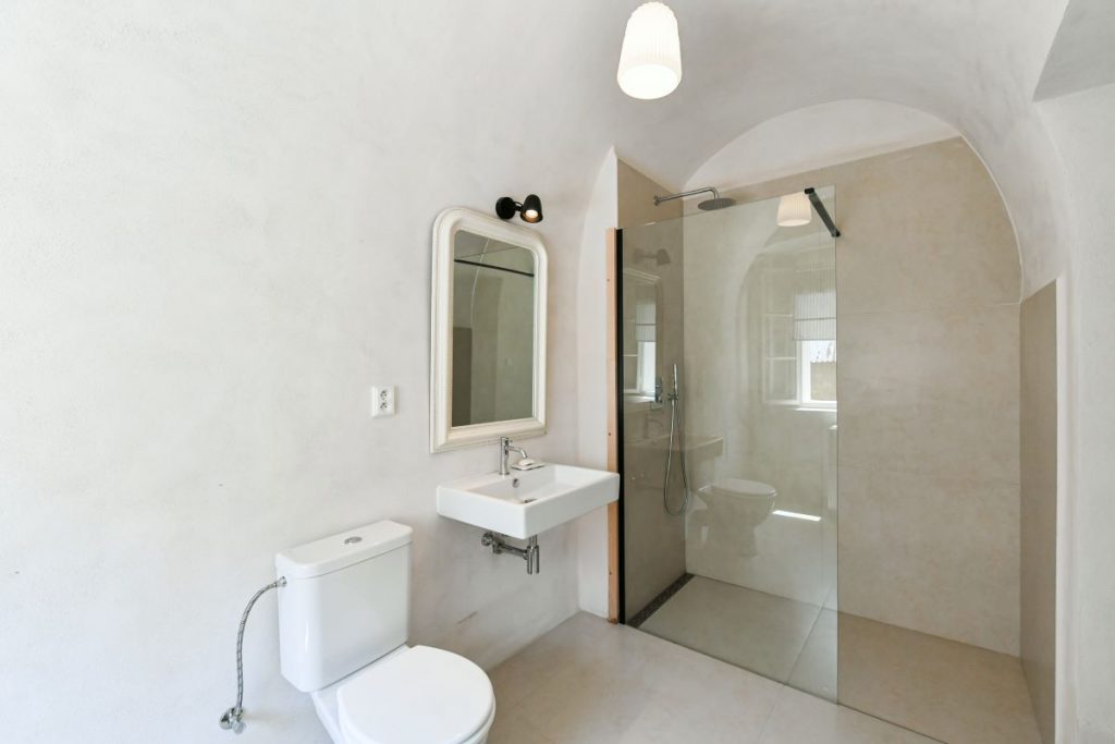 Kúpeľňa s toaletou a sprchovým kútom v zrekonštruovanej fare v Chudeniciach.
