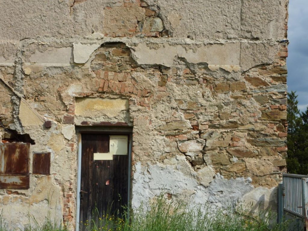 Detail poškodených stien a dverí na fare v Chudeniciach pred rekonštrukciou.