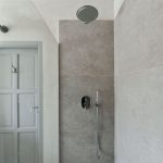 Sprchovací kút v minimalistickom dizajne v kúpeľni na fare v Chudeniciach.