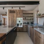 Moderná kuchyňa s drevenými rustikálnymi skrinkami a antikorovými pracovnými plochami.