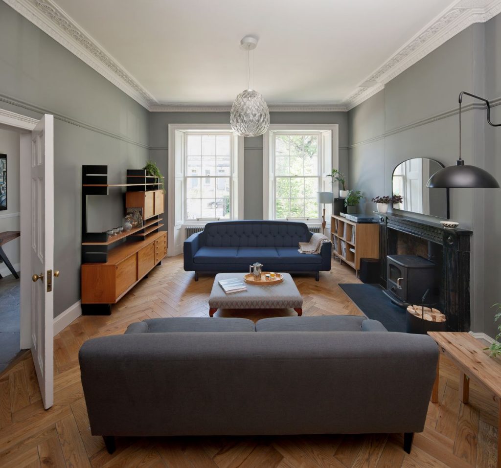 Priestranná obývacia izba s moderným nábytkom, krbom a veľkými oknami