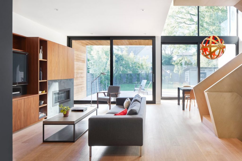 Priestranná obývacia izba s veľkými oknami, moderným nábytkom a výhľadom do záhrady.