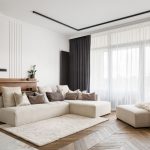 Nadčasová obývačka vo svetlých prírodných farbách a oknom so záclonou a tmavým závesom.