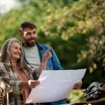 Halfpoint/iStock Starší muž a žena s plánom v ruke sa dívajú na okolie.