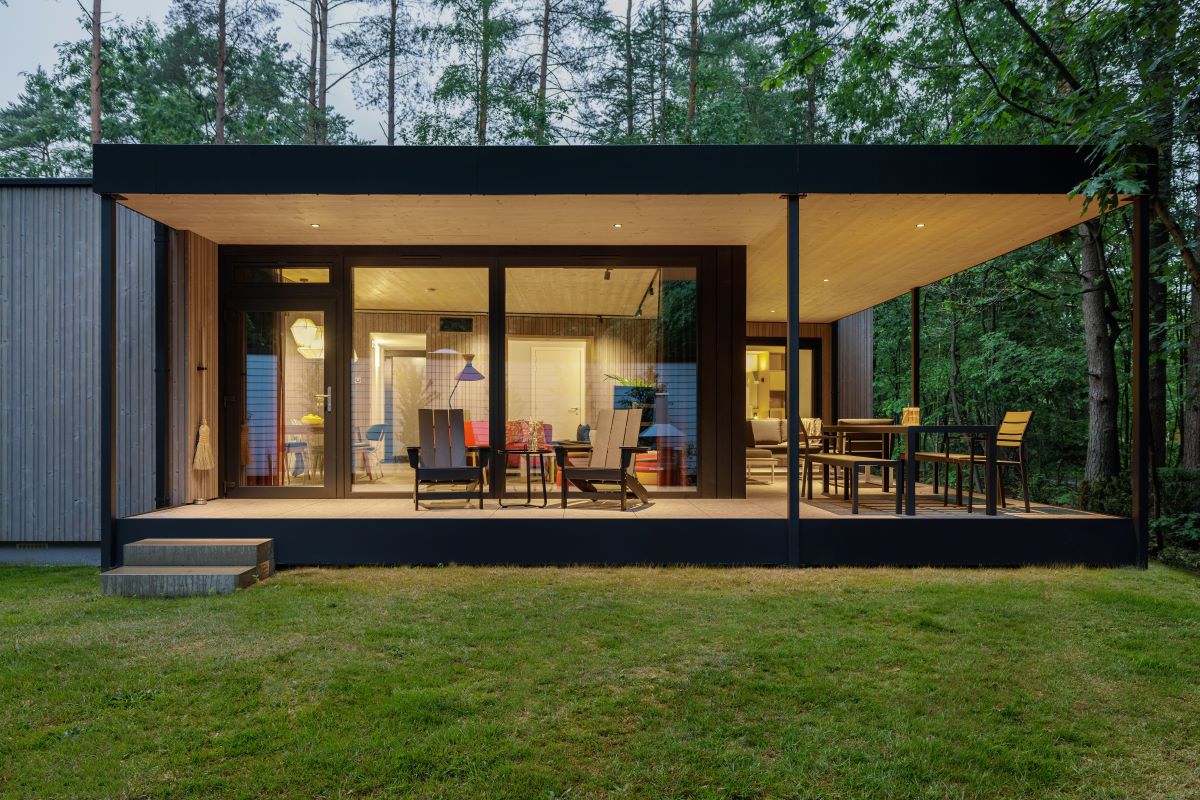 Oddychovú atmosféru bungalovu dosiahli veľkoformátovými oknami, ktoré vťahujú exteriér dovnútra.