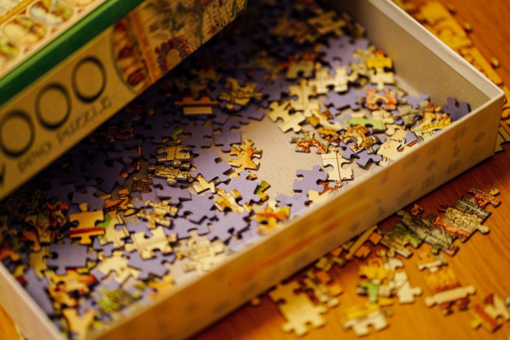Detail na škatuľu plnú puzzlí.