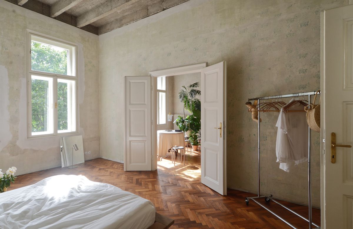 Moderná minimalistická spálňa, dvojkrídlové dvere, otvorený šatník, parketová podlaha.