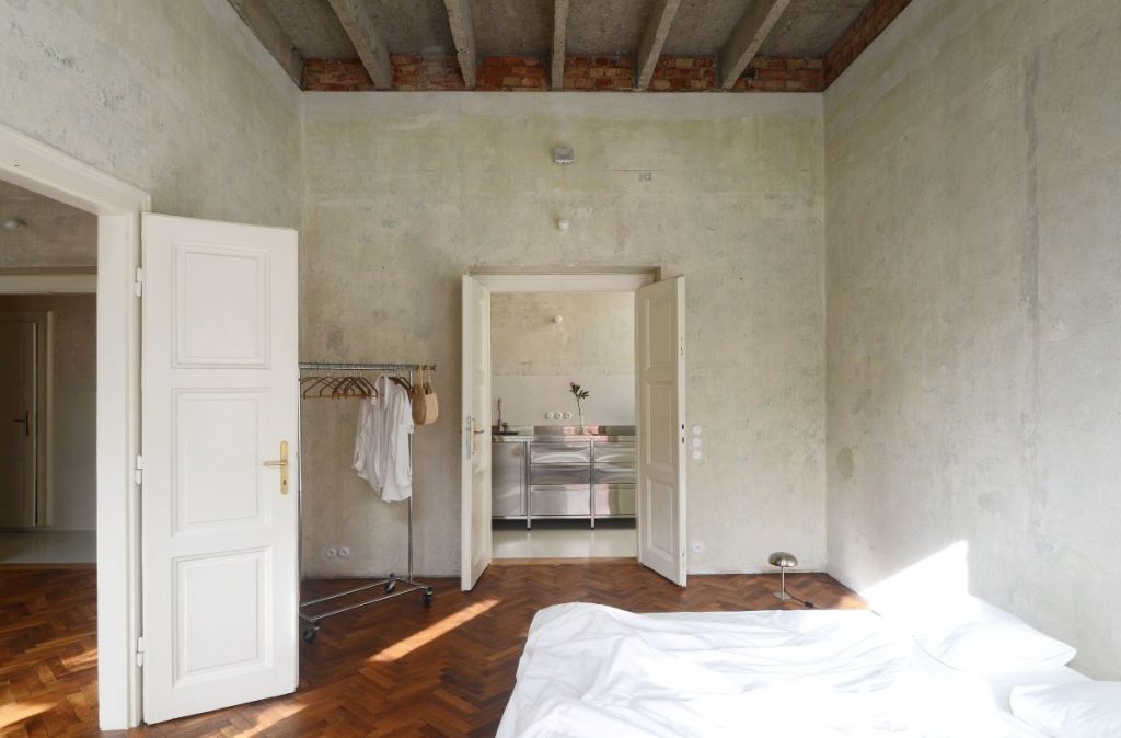 Spálňa v minimalistickom štýle s dvoma dvojkrídlovými dverami, otvorený šatník, parketová podlaha.