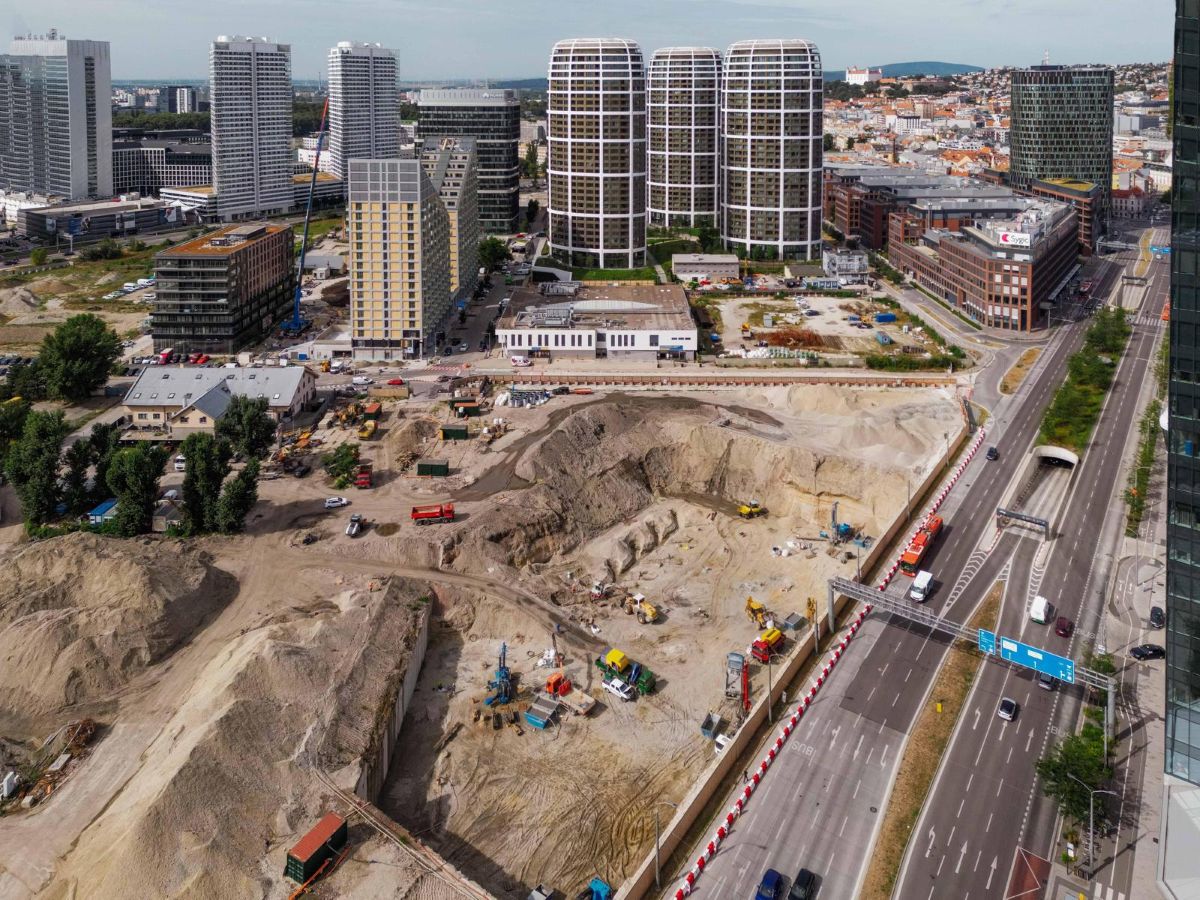 Rozsiahla stavebná plocha pripravovaná pre ekologické bývanie v modernom rezidenčnom projekte.