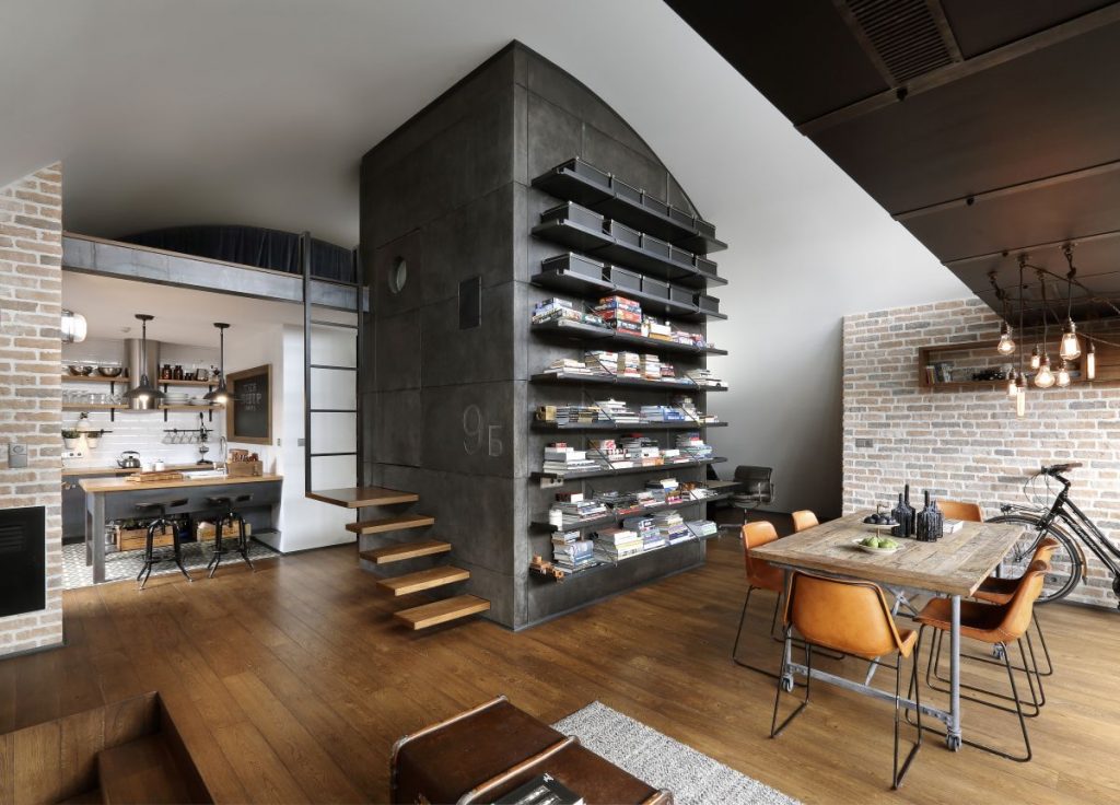Industriálny loft s otvoreným priestorom, drevenými podlahami a koženými stoličkami pri jedálenskom stole.