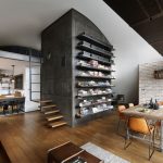 Industriálny loft s otvoreným priestorom, drevenými podlahami a koženými stoličkami pri jedálenskom stole.