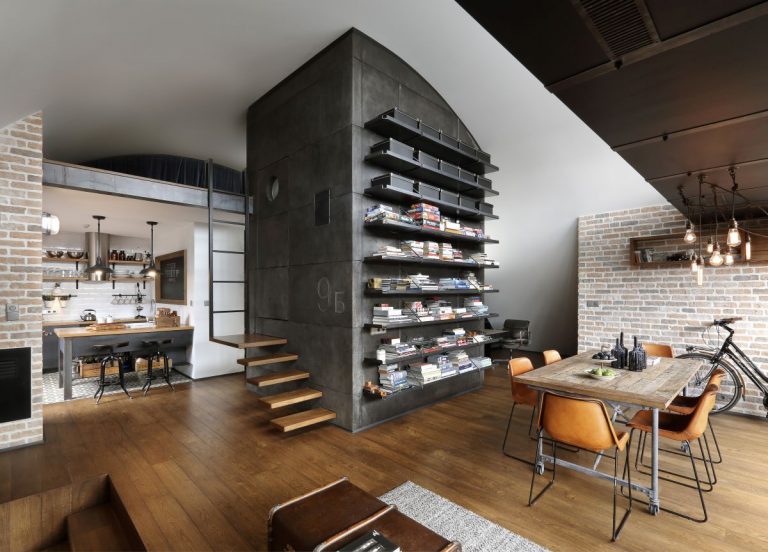 Industriálny loft s otvoreným priestorom, drevenými podlahami a koženými stoličkami pri jedálenskom stole.