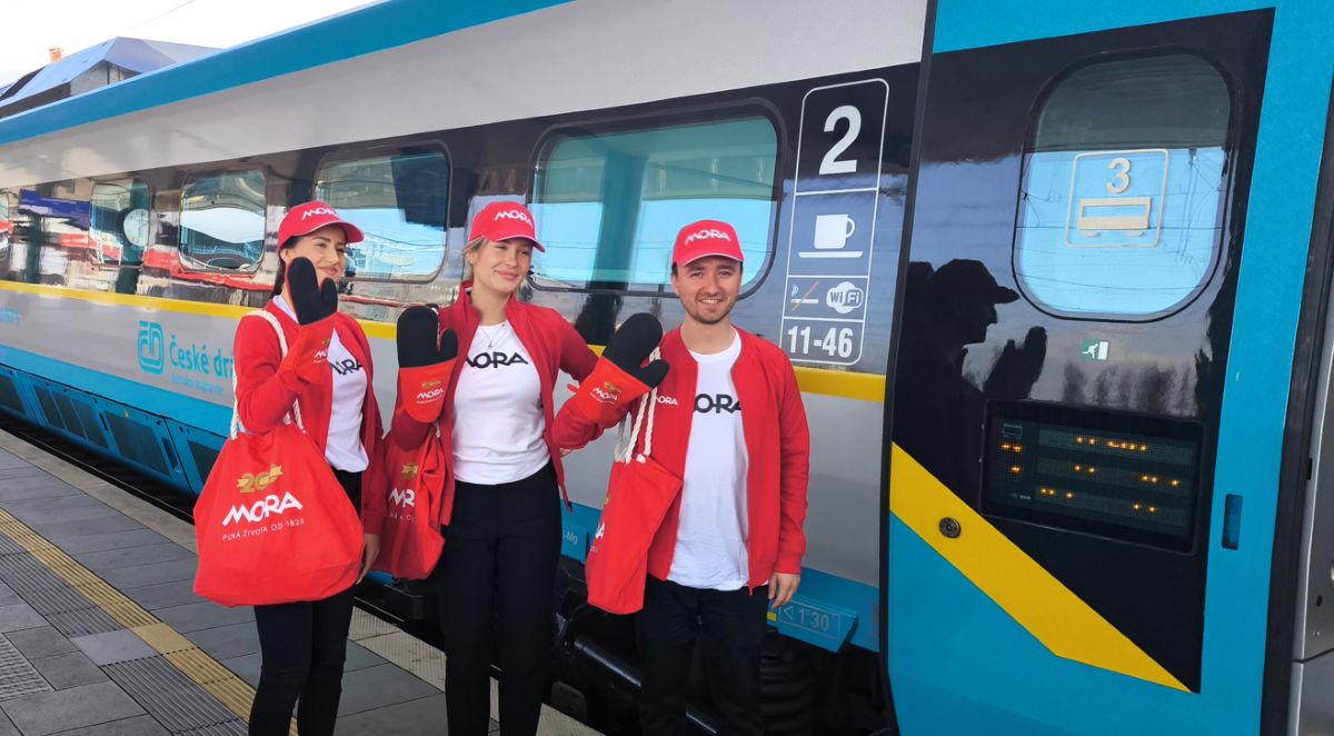 Mladí ľudia mávajúci pri vlaku České dráhy,.