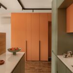 Minimalistická kuchyňa s nábytkom v odtieňoch oranžovej a zelenej farby.
