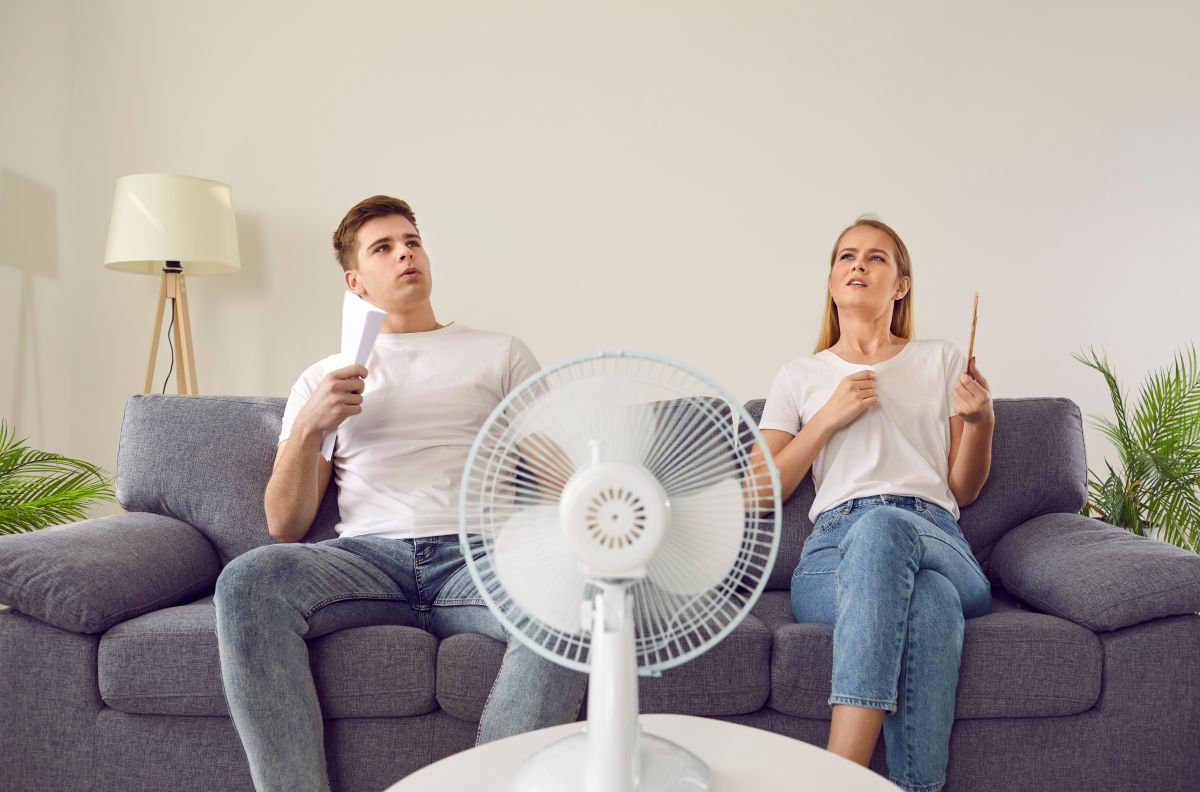 Mladý muž a žena sa ovievajú pri ventilátore.