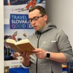 Pavel Dvořák pri čítaní knihy na besede.