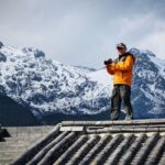 Pavel Dvořák na streche čínskeho domu pri fotografovaní.