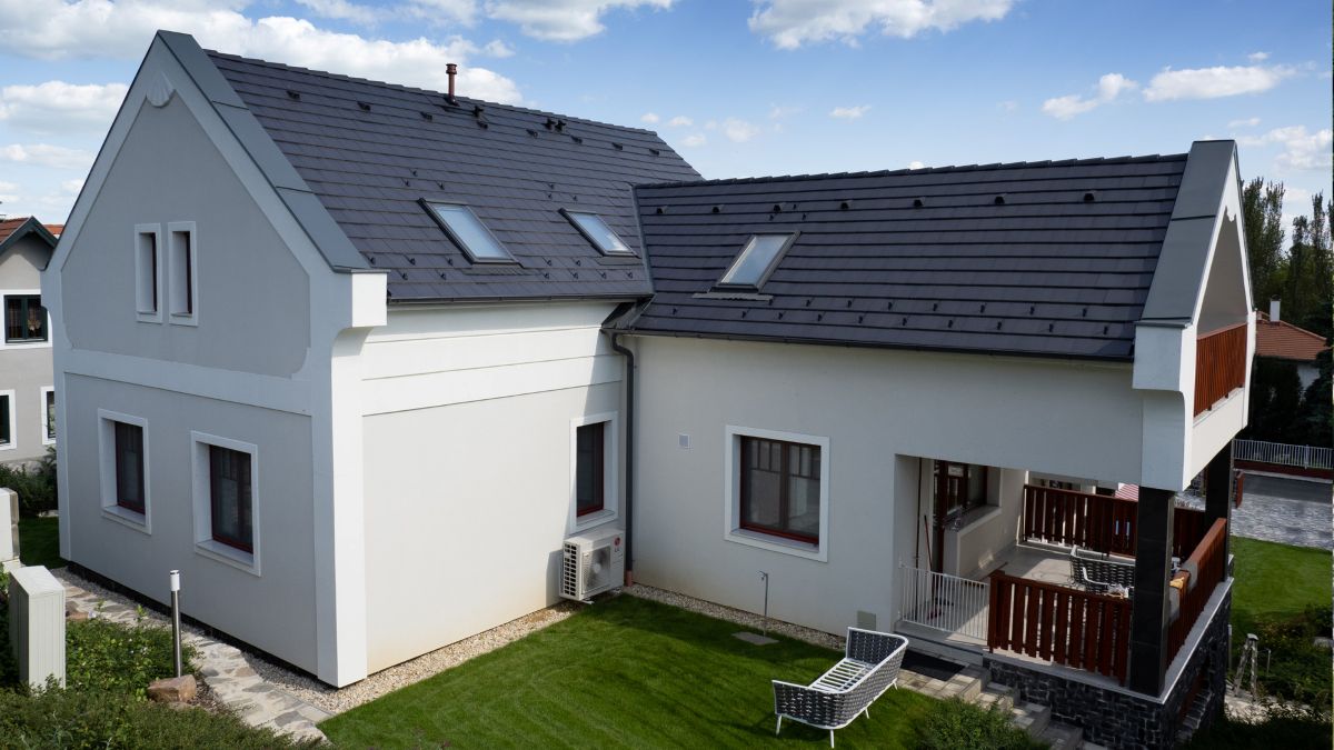 Zrekonštruovaný starší rodinný dom so šindľovou strechou.