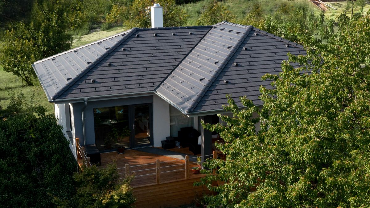 Moderný bungalov so sivou šindľovou strechou.
