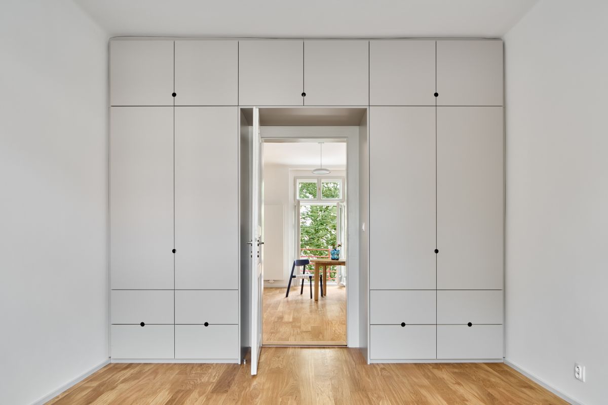 Aby v spálni zostalo čo najviac voľného miesta, umiestnili architekti praktickú vstavanú skriňu na celú výšku steny okolo dverí.