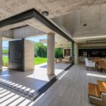 Prechod medzi interiérom a exteriérom s terasou a vstupom do záhrady v betónovej vile.