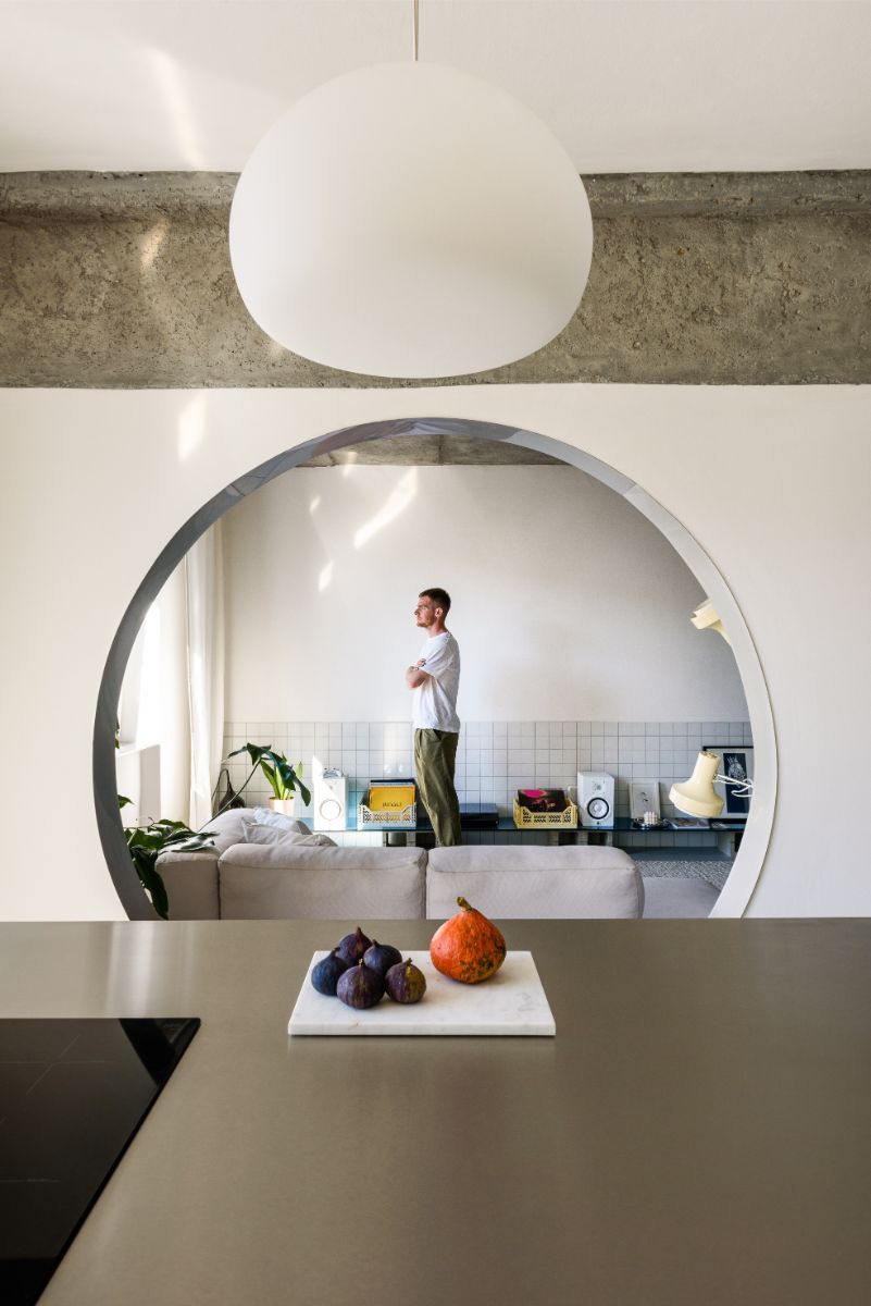 Architekt Alan Prekop vo vlastnom byte pri sedačke, obrátený smerom k oknu.