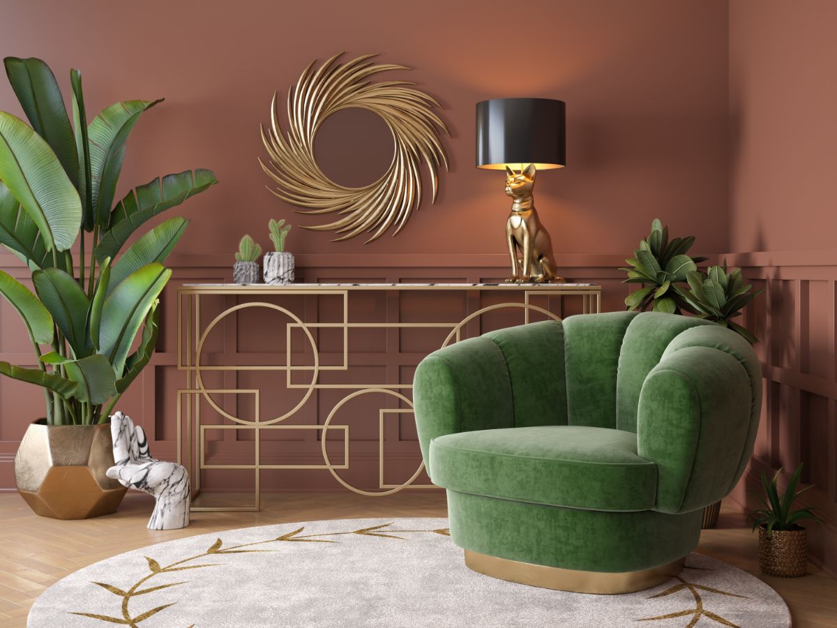 Art deco interiér s terakotovou stenou, zeleným zamatovým kreslom a zrkadlom so zlatým rámom.