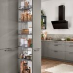 Vysoká sivá kuchynská skriňa s výsuvným potravinovým systémom plným zaváranín a sypkých potravín.