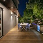 Drevená terasa s vonkajším stolovaním a nerezovým grilom.