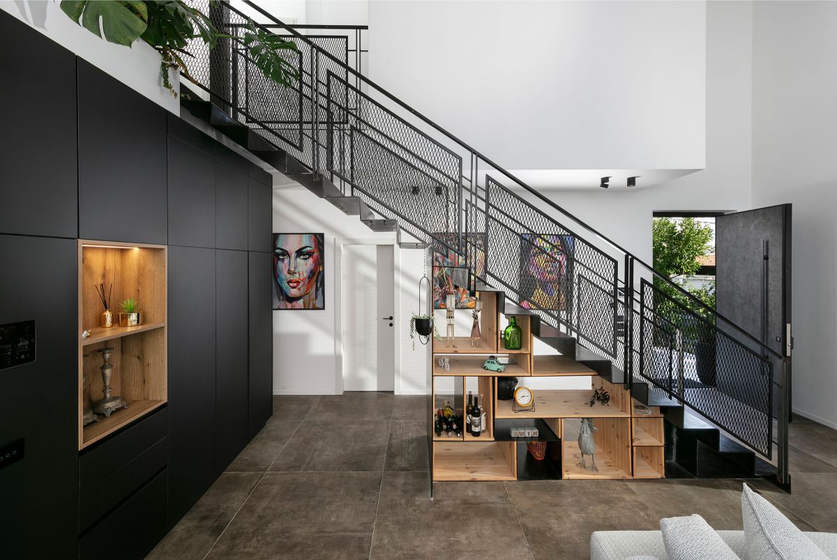 Kovové zábradlie schodiska pôsobí vďaka perforovaným panelom odľahčene.