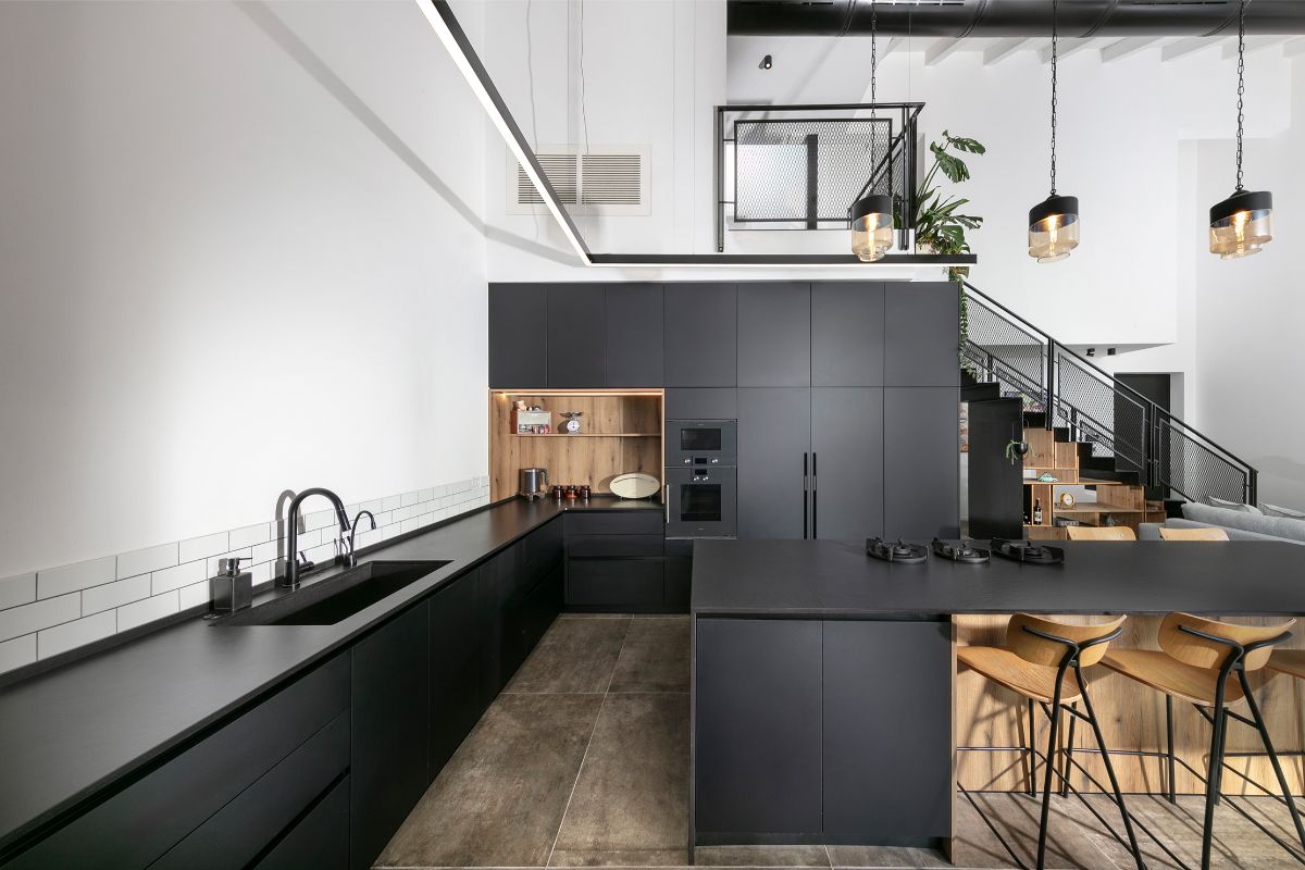 Kuchyňa je vytvorená ako grafitový blok, doplnená o niky vyložené dubovým drevom. 