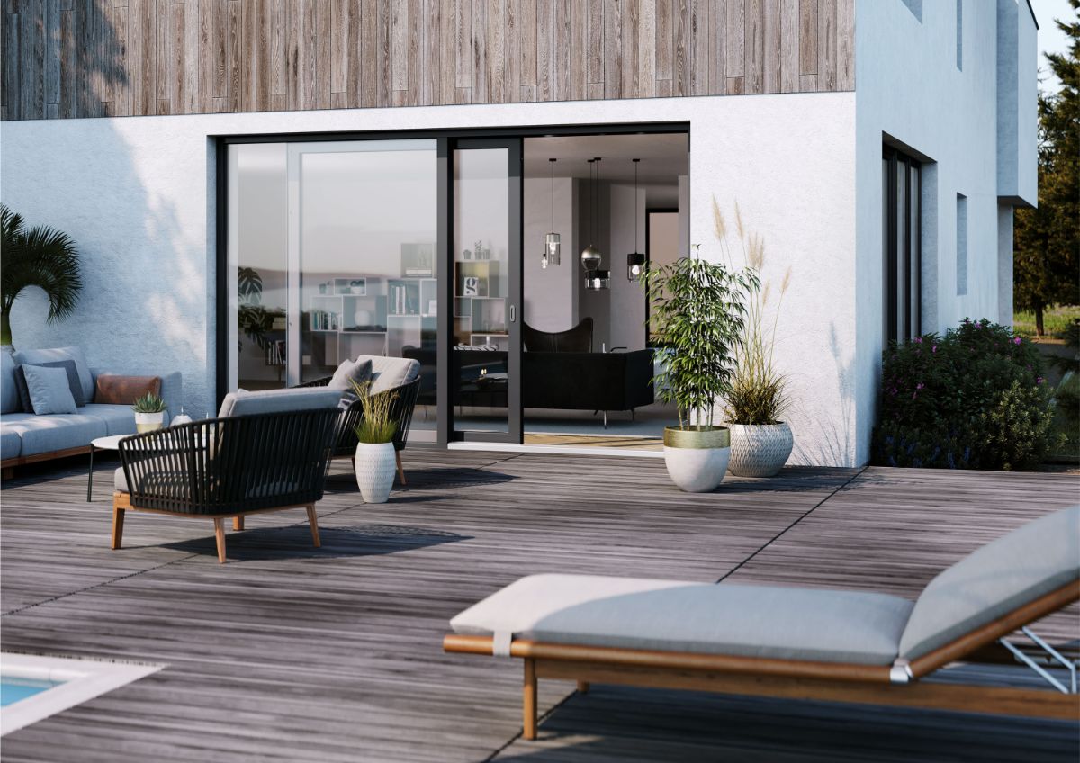 Biely rodinný dom s dreveným obkladom, terasou a posuvnými dverami v tmavom ráme.