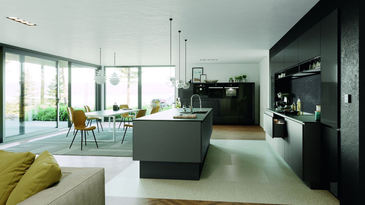Priestranná moderná kuchyňa s tmavými skrinkami, ostrovčekom a veľkými presklenými posuvnými dverami.