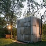 Upcyklovaná sauna s komínom na dvore v prírodnom prostredí.