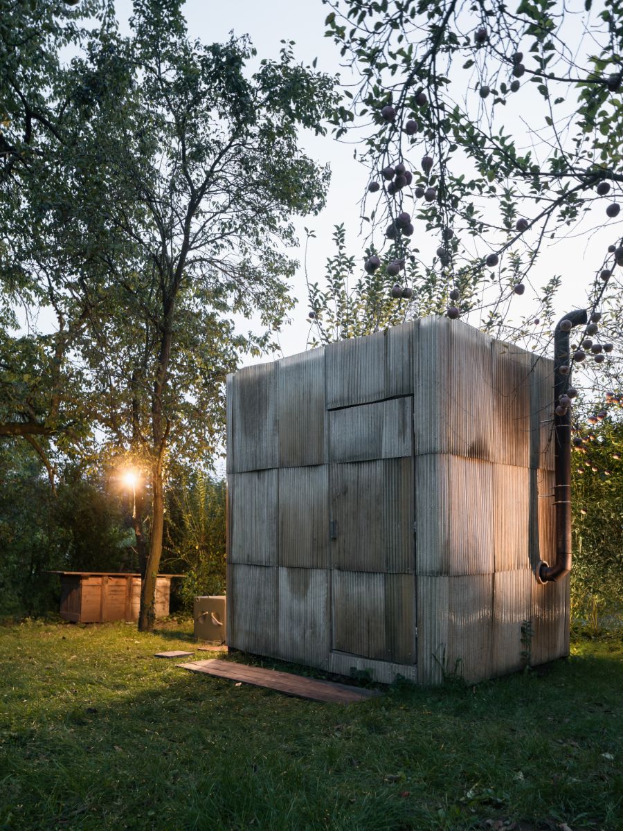 Upcyklovaná sauna s komínom na dvore v prírodnom prostredí.