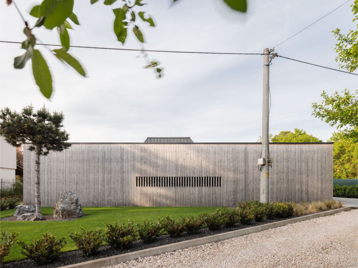 Átriový dom pôsobí moderne, ale zároveň pracuje s prírodnými materiálmi tak, aby zapadol do konceptu vidieckeho života.