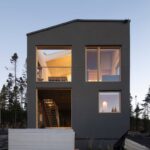 Dom hlboko v lese s veľkoformátovými oknami.