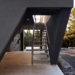 Vstup do domu s drevenou podlahou a lezeckou stenou s chytmi.