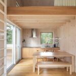 Kuchyňa s jednoduchou drevenou linkou, jedálenským stolom s lavicou a rebríkom do podkrovnej časti.