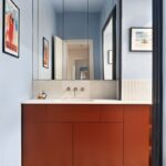 Moderná kúpeľňa s tmavohnedou skrinkou pod umývadlom a farebnými vzorovanými dlaždicami na podlahe.