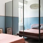 Hlavná spálňa s posteľou v ružovej farbe a skriňou so zrkadlovými dverami.